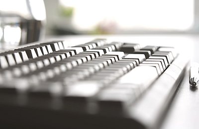 Nahaufnahme einer schwarzen Computer-Tastatur auf einem Schreibtisch in Büroumgebung